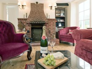 a living room with a bottle of wine and wine glasses at Church Cottage in Islip