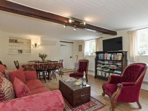 a living room with a red couch and a table at Church Cottage in Islip