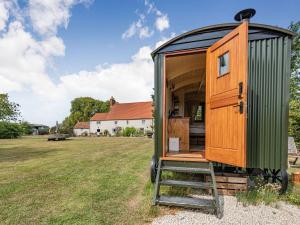 una casita verde con una escalera en un campo en The Nuthatch - Uk40297 en Martin