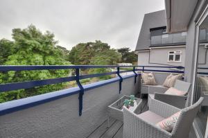 a balcony with chairs and tables on a house at Mauve in Poole