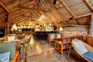 un restaurante con sillas y mesas y un bar en Finca Luna Nueva Lodge en Fortuna