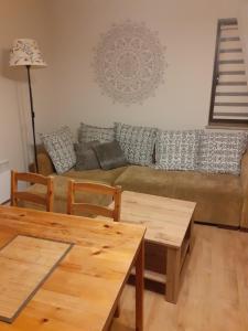un soggiorno con divano e tavoli in legno di Apartament Białka 302A a Białka