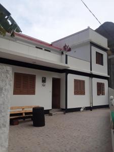 a white house with a door and a bench in front at CASA MINGA & TATOL in Ribeira Grande