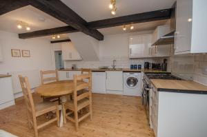 a kitchen with a wooden table and a table and chairs at Hideaway Cottage in Bristol