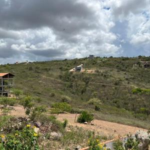 a hill with a house on top of it at Chalé bons ventos in Serra de São Bento