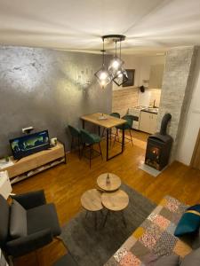 a living room with a table and a fireplace at Apartman Ninkovic in Pale +26 photos