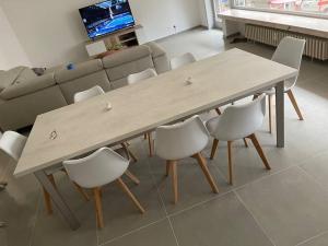 德帕内Appartement la panne Vue laterale sur mer的客厅配有一张木桌和椅子 更多7张照片