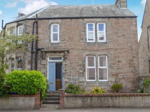 an old brick house with a blue door at Rockhill in Inverness