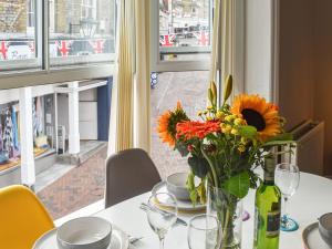 a vase of flowers on a table with a window at Shooters Cross Apartment in Cowes