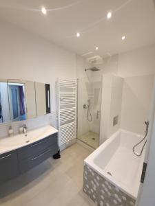 a white bathroom with a tub and a shower at Altstadtapartments Werder in Glindow +76 photos