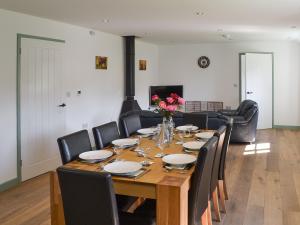 a dining room with a wooden table and chairs at East Croft Barn in Halwill