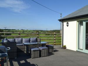 a patio with a table and chairs and a fence at East Croft Barn in Halwill