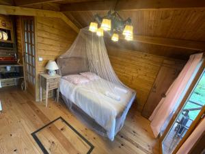 a bedroom with a bed with a mosquito net at 7eme ciel - Tiny House avec Grande Piscine intérieure chauffée toute l'année in Marais-Vernier