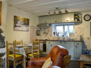 a kitchen with a table and a dining room at Castiel Cottage in Yspytty-Ifan