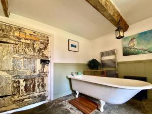 Chew Stoke的住宿－Yew Tree Farm，配有白色浴缸的带绘画的浴室