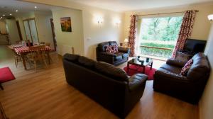 a living room with two couches and a dining room at Allt Beag in Lochearnhead