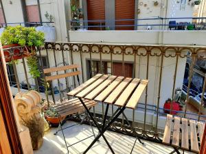 カターニアにあるBellini Apartmentの木製ベンチ、バルコニー(テーブル付)