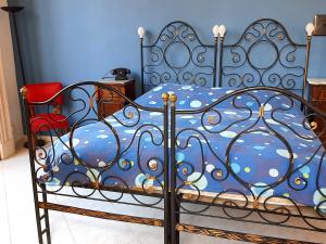 a bedroom with a bed with a blue bedspread at Bellini Apartment in Catania