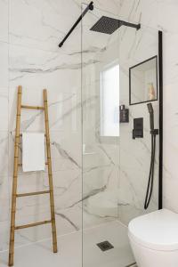 uma casa de banho com uma cabina de duche em vidro e uma escada. em BNBHolder Cool Atocha Station em Madri