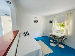 1 dormitorio con cama, escritorio y ventana en La Casa del Rey de las Ballenas en Puerto Pirámides