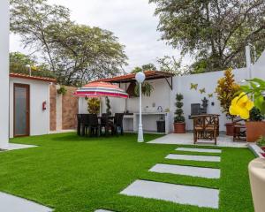 a backyard with grass and an umbrella and a table at Hermosa Casa de Playa Machalilla in Machalilla