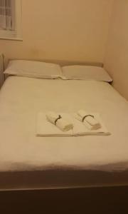Double room for One Person in 3 beds flat في لندن: سرير ابيض وفوطه منشفتين