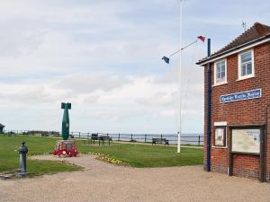 a building with a kite flying over the ocean at Beachcomber in Mundesley