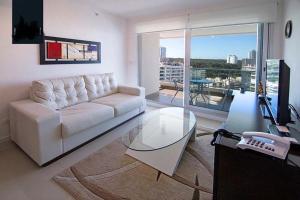 uma sala de estar com um sofá branco e uma mesa de vidro em Apartamento Punta del Este,Wind Tower 2 dormitorios em Punta del Este
