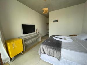 a bedroom with a bed and a flat screen tv at Carrapicho Patacho com Piscina Privativa in Pôrto de Pedras