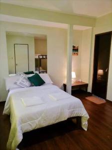 Un dormitorio con una gran cama blanca y una mesa en Sanset Villa 1 and 2 en Alburquerque