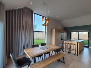 una cucina e una sala da pranzo con tavolo e sedie in legno di Bailgate Barn, Ashlin Farm Barns a Lincoln