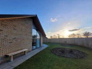 un edificio in mattoni con una panchina in un cortile di Bailgate Barn, Ashlin Farm Barns a Lincoln