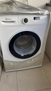 una lavadora blanca en el suelo en Apartamento Piscina 1G by Urraca Suites Viveiro, en Viveiro