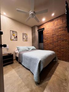 sypialnia z łóżkiem i wentylatorem sufitowym w obiekcie Bunde Haus Hotel EXPRESS BOUTIQUE w mieście Ibagué