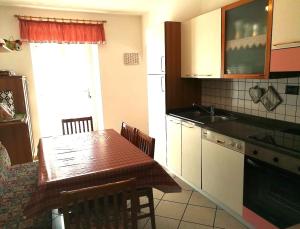 a kitchen with a wooden table and a kitchen with a sink at Appartamento Flora in Tesero