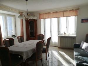 comedor con mesa, sillas y sofá en Appartamento Flora en Tesero