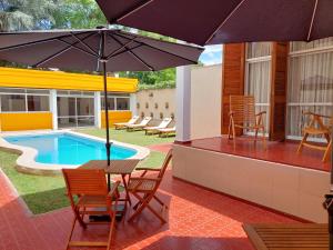 a patio with a table and an umbrella next to a pool at La Casa del Parque B&B in Mendoza