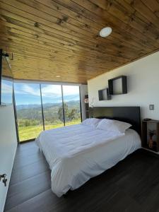 a bedroom with a large bed with a large window at Vaikuntha House 