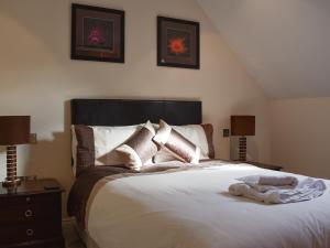 een slaapkamer met een groot wit bed met 2 lampen bij The Dell in Minehead