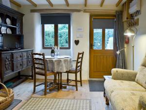 a living room with a table and chairs and a couch at Annies Cottage in Buckland Monachorum
