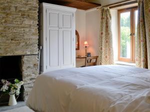 sypialnia z białym łóżkiem i kominkiem w obiekcie Annies Cottage w mieście Buckland Monachorum