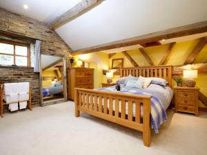 a bedroom with a wooden bed and yellow walls at Birch Cottage - Uk4185 in Hazlehead Bridge