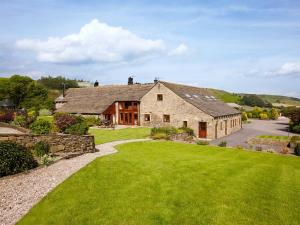 a large stone house with a green lawn at Birch Cottage - Uk4185 in Hazlehead Bridge