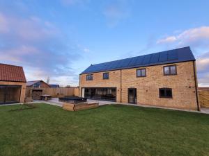 uma casa de tijolos com painéis solares em Eastgate Barn, Ashlin Farm Barns em Lincoln