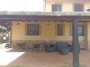eine Terrasse mit Stühlen und Tischen vor einem Haus in der Unterkunft BELLA ASSISI B & B in Assisi