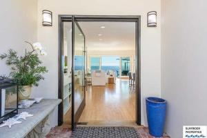 a glass door leading to a living room with the ocean at Malibu Road Beachfront Charmer in Malibu