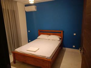 a bedroom with a bed with a blue wall at place to be saidia in Saïdia