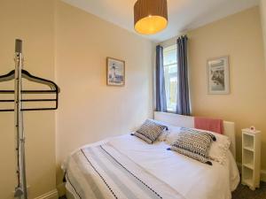 um quarto com uma cama com almofadas em Largs Brisbane Cottage em Largs