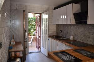a kitchen with white cabinets and a door leading to a patio at Duplex Flamenca Beach La Zenia Boulevard in Orihuela Costa