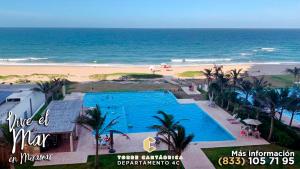 uitzicht op een zwembad en het strand bij Vive el Mar en Miramar in Altamira